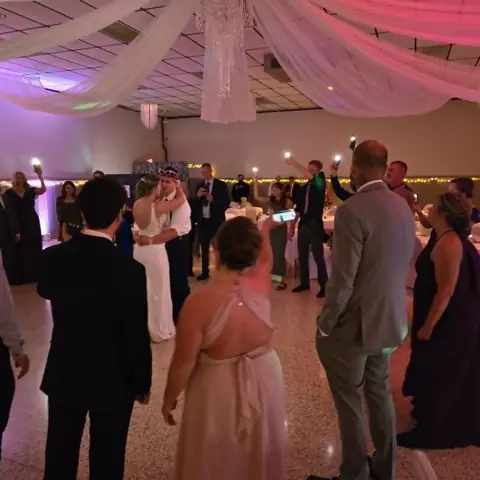 Wedding celebration with guests gathered around the couple